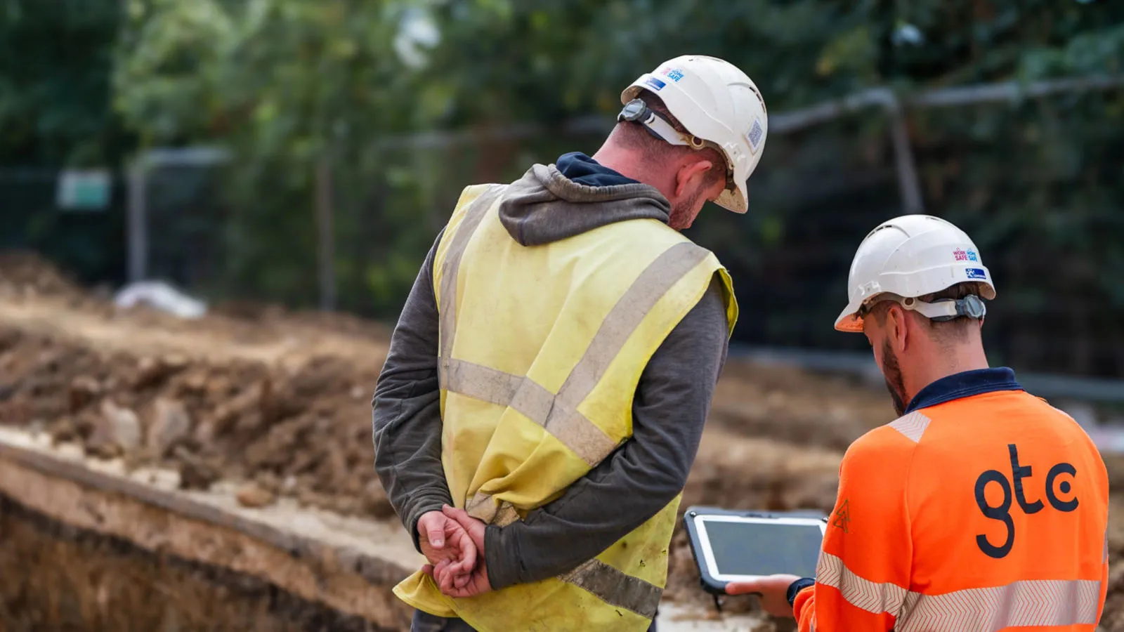 Workers looking at tablet on construction site